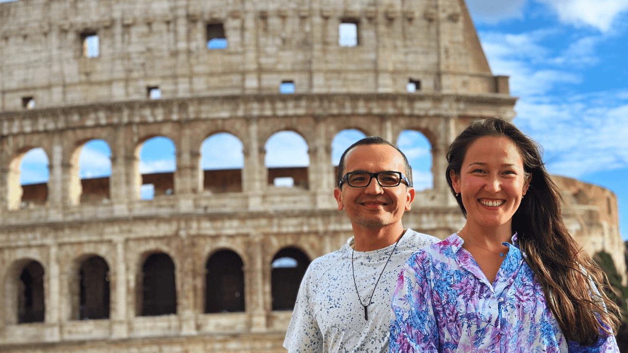 Fado Ghani and his wife smiling in front of the Colosseum in Rome